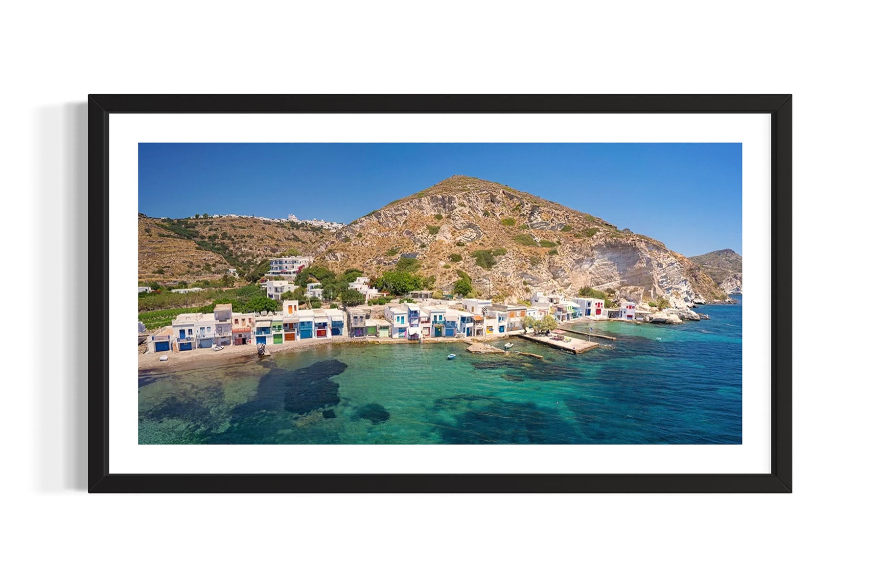 Framed aerial photograph of Klima, Milos, Greece coastal village with colorful houses and clear blue water by Evan Reinheimer.
