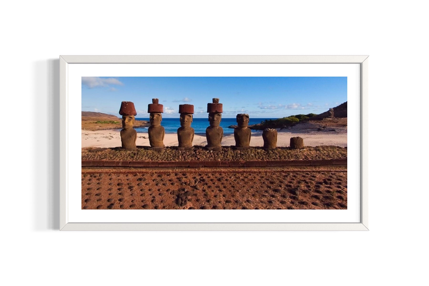 Framed photograph of stone Moai statues on an Easter Island beach with ocean and sky in the background.