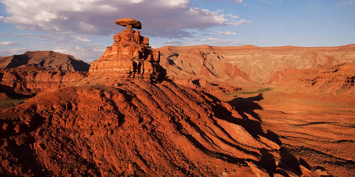 Aerial photograph of the Mexican Hat Rock and desert landscape in Utah by Evan Reinheimer.