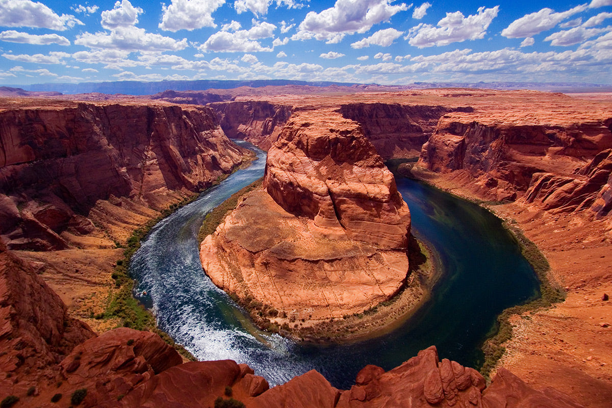 Aerial photograph of Horseshoe Bend in Page, AZ with a river cutting through red rock formations by Evan Reinheimer.