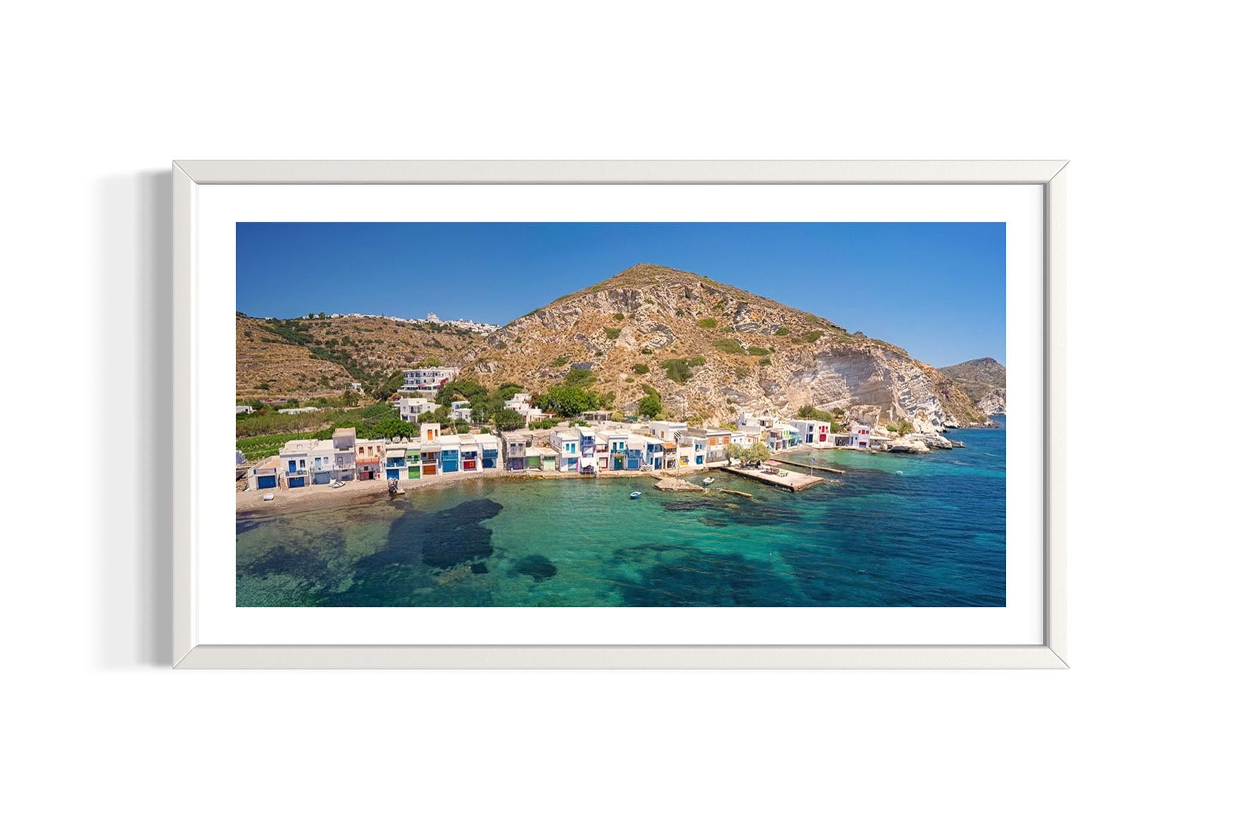 Framed aerial photograph of Klima, Milos, Greece coastal village with colorful houses and clear blue water by Evan Reinheimer.