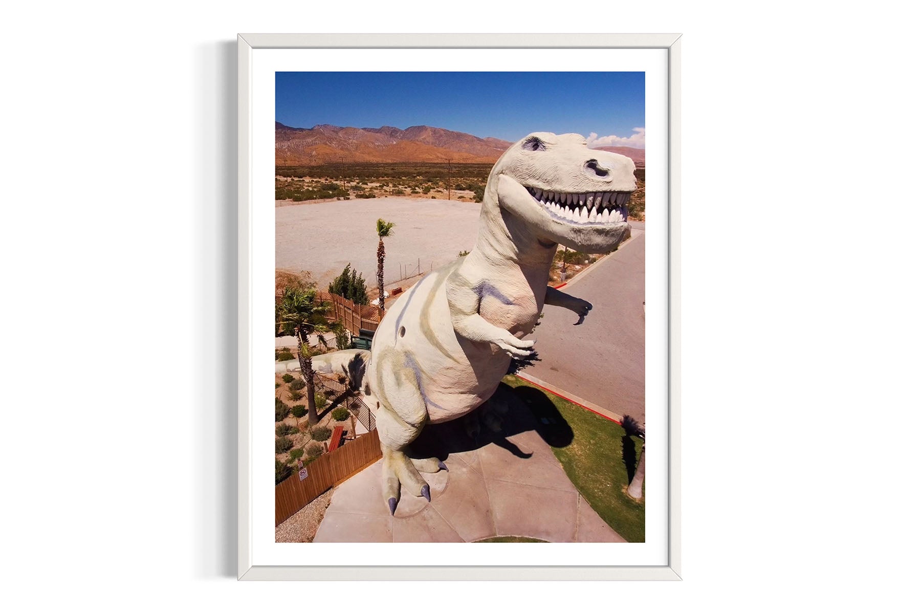 Framed aerial photograph of a T-Rex statue in Cabazon, CA desert landscape by Evan Reinheimer.